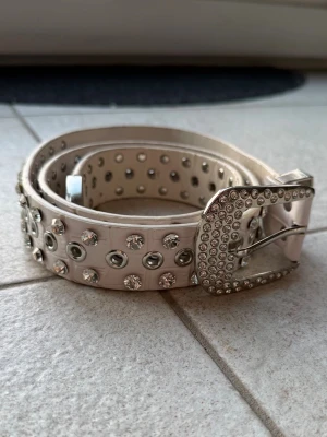 Bälte från SHEIN  - Säljer ett silvrigt/vitt bälte med paljettdetaljer från SHEIN. Den är onesize 🖤
