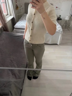 Krämvit kortärmad kofta med knappar  - Säljer en stickad kofta från Gina Tricot i storlek M. Säljer den på grund utav att den aldrig kommer till användning, så precis som nytt skick. Hör av dig om du har någon fråga! (Finns fler bilder i en annan annons jag har uppe)