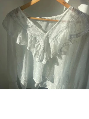 Vit blus med volang och spetsdetaljer - Vit blus från only i strl M. Använd vid endast 3 tillfällen och är nästan helt ny! Nypris: 350kr 💗