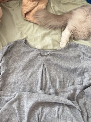 Grå mjuk loungewear-tröja - Supermjuk grå loungewear-tröja med rund halsringning och avslappnad passform. Perfekt för chill dagar hemma. Materialet känns skönt mot huden och har en enkel, stilren look.