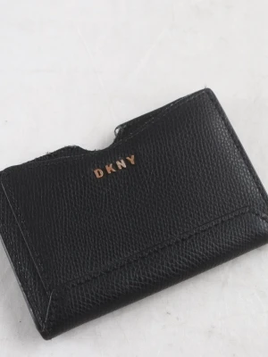 Svart korthållare från DKNY - Snygg svart korthållare från DKNY i äkta läder med guldfärgad logga framtill. Stilren och kompakt design med plats för flera kort. Perfekt att ha i fickan eller väskan när du vill hålla det enkelt och classy.