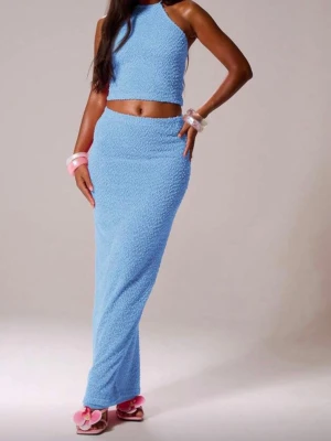 Blått set med topp och lång kjol - Säljer ett snyggt blått set med en ärmlös crop top och en lång, figurnära kjol i strukturerat tyg. Perfekt för dig som vill ha en modern och trendig look. Materialet ser ut att vara mjukt och bekvämt.