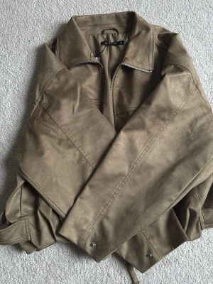 Ginatricot jacks  - Snygg olivgrön jacka från Ginatricot som trendar just nu. Jackan har dragkedja framtill, klassisk krage och breda ärmar. Är i helt nytt skick.