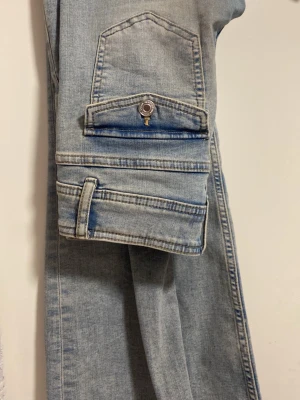 Ljusblå lowwaist jeans med dubbelknappar - Säljer ett par ljusblå lowwaist jeans denim från Kappahl med snygga bakfickor. Jeansen har coola sömdetaljer och knappstängning på fickorna. Perfekta för en avslappnad och trendig streetwear-look. I storlek 152 köpta för 300 säljer för 100 kan tänka mig sänka pris kontakta vid sänkning isåfall💕