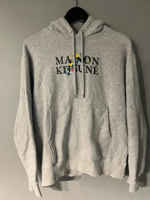 Grå hoodie från Maison Kitsuné - Grå hoodie från Maison Kitsuné säljes. Använd väldigt lite och är i fint skick utan slitage. Storlek S vilket är svårare att få tag på.  Skickar snabbt och kan självklart skicka fler bilder eller svara på frågor vid intresse..