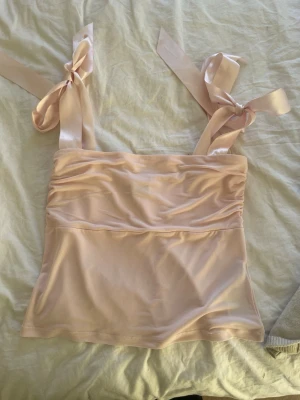 Rosa topp med rosetter - Söt rosa topp från Gina tricot med rosetter på axlarna. Nice till sommaren . Aldrig använd priset kan förhandlas💕