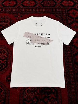 Maison Margiela vit t-shirt med tryck - Vit t-shirt från Maison Margiela perfekt för sommar outfits. | skick : 10/10 har endast använts fåtal gånger så ser ut som ny. | etiketten och påsen följer med på köp! | Storlek EU S | längd : 64 cm | bredd : 46 cm | pris går att diskutera vid bundle köp / snabbaffär! 💯
