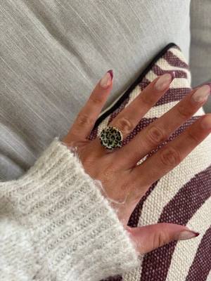 Ring med knapp  - Säljer denna handgjorda ring.  Knapparna är vintage men själva ringen/ringstommen är helt ny och oanvänd. Materialet är rostfritt stål och varken tappar färg eller färgar av sig på huden. Ringen tål vatten. Storleken är justerbar, man kan trycka ihop och dra isär ringen till önskad storlek. Perfekt för dig som vill bära något unikt!