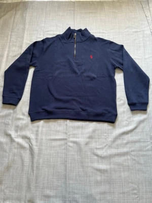 Ralph lauren quarter zip mörkblå strl L - Säljer en helt ny Ralph Lauren quarter zip i mörkblå färg. Väldigt populär modell och färg som alltid säljer snabbt. Perfekt passform och clean look som funkar både till vardag och finare outfits. Oanvänd i storlek L snabb frakt och bundlepris vid flera köp