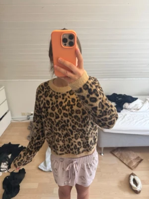 Leopardmönstrad stickad tröja Zara - Mysig stickad tröja från Zara med leopardmönster i beige och bruna toner. Tröjan har rund halsringning och ribbade muddar vid ärmslut och nederkant. Perfekt för dig som vill ha en trendig och djurinspirerad look. Tröjan är väldigt liten i storleken så L är typ som en XS/S skulle ja säga! Den är aldrig andvänd.