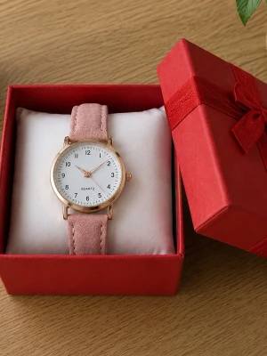 Rosa klocka med guldiga detaljer - Stilren klocka med ljusrosa band i mockaimitation och rund vit urtavla. Boetten är guldfärgad och urtavlan har tydliga svarta siffror. Perfekt accessoar för dig som vill ha en enkel men snygg look.. boxen ingår.