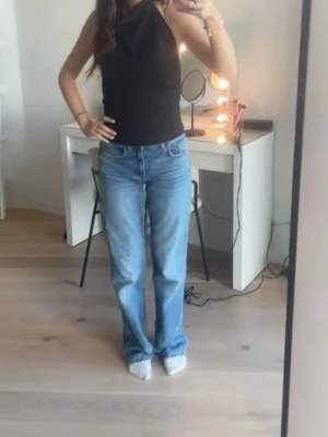 Blå jeans från Zara - Säljer ett par blåa jeans från Zara i modellen wide leg. Jeansen har fem fickor, bälteshällor och stängs med dragkedja och knapp. Perfekta till vardagslooken och passar till det mesta. Materialet är denim i bomull. Jeansen är sparsamt använda men har lite slitningar längst ner vid fötterna som knappt är synliga när dem bärs💓