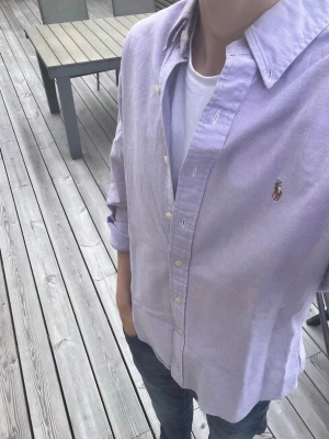 Ralph Lauren Skjorta - Riktigt snygg skjorta från Ralph Lauren. Slim fit storlek M. Oxford. Perfekt till sommaren.☀️Skjortan är ljuslila men ser nästan rosa ut.  Bara att skriva vid funderingar! 