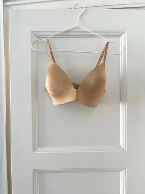 SKIMS tshirt bh  - Oanvänd (endast provad)  bh från Skims, säljs pga fel storlek. Skönaste bh jag har testat, perfekt under tajta plagg, väldigt smickrande och formar bysten väldigt fint. 36C/80C. Nypris runt 700kr. 