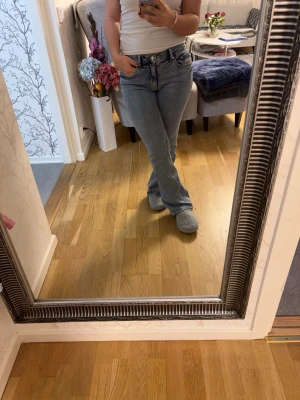 Ljusblå bootcut med låg midja  - Säljer ett par ljusblå jeans bootcut och låg midja. Jeansen har klassisk femficksdesign och en avslappnad passform som ger en cool och tidlös look. Perfekta att matcha med en enkel t-shirt eller hoodie.