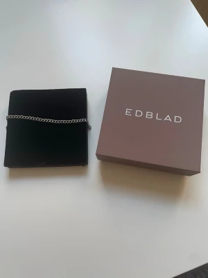 Silverfärgat kedjearmband från Edblad - Stilrent armband från Edblad i rostfritt stål med klassisk tunn kedjedesign. Perfekt för dig som gillar minimalistiska accessoarer och vill ha något som funkar till många olika looks. Levereras i originalask.