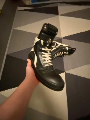 Svarta Rick Owens Chrome hearts Geobasket  - Säljer ett par svarta och vita Rick Owenns Chrome hearts collab tyvvär inte äkta för de riktiga kostar ungefär 40k sitter fint storlek 41 har några tecken på användning men har bara använt ett par gånger. Kan såklart gå ner i pris