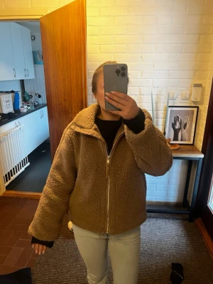 Beige teddyjacka med dragkedja - Mysig beige teddyjacka med hög krage och dragkedja framtill. 