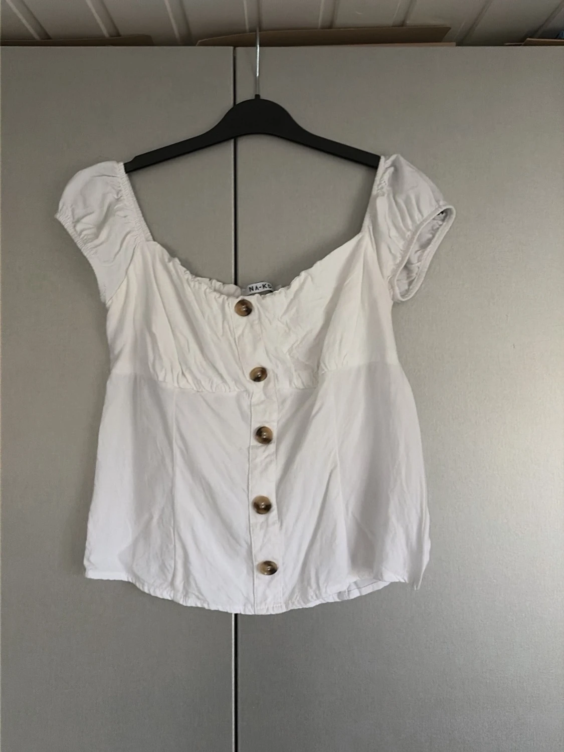 Vit blus med knappar från NA-KD