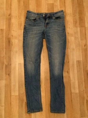 Jeans - Säljer dessa snygga jeans för att de inte kommer till någon användning. De har legat i ett skåp i flera år orörda. Vänstra fickan är sönder och har ett stort hål. På bilden är de tvättade. Märket är oklart. Skriv vid funderingar. 