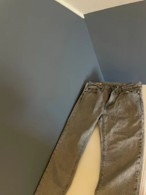 Grå Levi's raka jeans - Säljer ett par grå raka jeans från Levi's med klassisk femficksdesign och läderpatch bak i midjan. Jeansen har normal midja och är tillverkade i ett slitstarkt bomullsmaterial. Perfekta för dig som gillar en clean och tidlös look.  Storlek 30/30 skriv gärna vid funderingar 