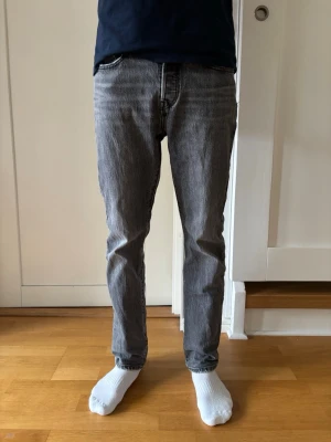 Grå Levi's 501 jeans - Säljer ett par klassiska grå Levi's 501 jeans med rak passform. Dem är i fint men använd skick. Fickorna är lite slita som syns på bilderna. Storlek W27 L30