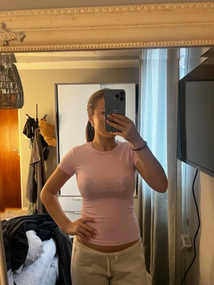 Ljusrosa t-shirt från Gina Tricot - Säljer en ljusrosa t-shirt från Gina Tricot i storlek XS. T-shirten är tight och har korta ärmar. Väldigt fin till sommarn men även året om. 