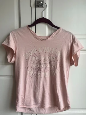 Ljusrosa Zadig Voltaire T-shirt - Säljer min rosa Zadig tröja! Lite lägre pris pga av litet hål på ryggen (inte särkilt märkbart)❤️ sitter inte helt tajt på mig som är xs, fungerar på både xs/S/xxs