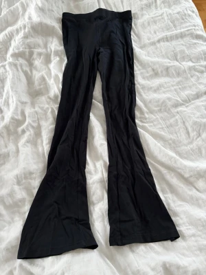 Svarta utsvängda leggings - Säljer ett par svarta leggings med utsvängda ben. Dem är tillverkade i ett mjukt stretchigt material som sitter tight upptill och släpper ut nedtill för en snygg siluett.🩷🌸