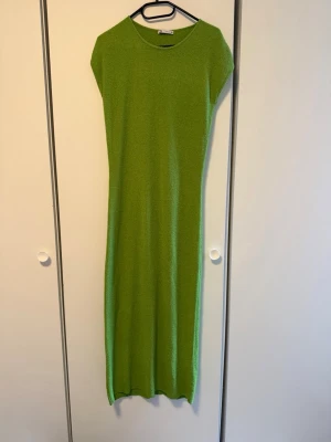 Grön långklänning från Zara - Säljer en enkel och stilren grön långklänning från Zara. Klänningen har rund halsringning, ärmlös design och rak passform. Perfekt för dig som gillar minimalistisk stil och vill ha något bekvämt och snyggt.