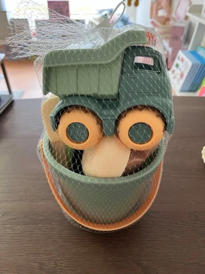 Grönt sandset med lastbil och formar - Säljer ett sandset med en grön plastlastbil, två hinkar i grönt och beige, spade och kratta samt djurformar. Perfekt för lek i sandlådan eller på stranden. Setet är tillverkat i tålig plast och har mjuka färger i grönt, beige och orange. 100% giftfritt 