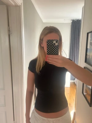 Mörkblå tight t-shirt - Säljer en mörkblå t-shirt med korta ärmar och tight passform. Perfekt för dig som gillar en enkel och stilren look. Materialet känns mjukt och stretchigt, vilket gör den bekväm att bära hela dagen.