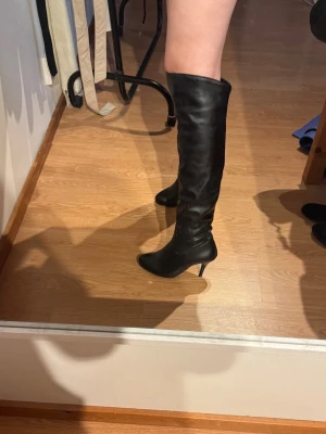 Svarta overknee stövlar med klack - Snygga svarta overknee stövlar i läderimitation med smal klack. 