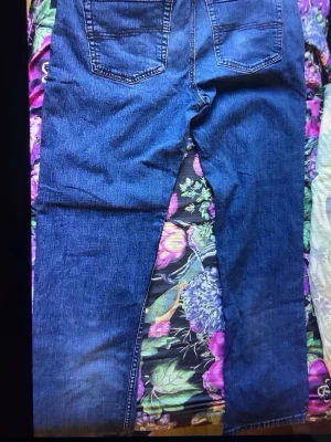 Blå raka jeans med bakfickor - Snygga blå jeans med klassisk rak passform och två stora bakfickor. Jeansen har en tidlös look med tydliga sömmar och är perfekta för en avslappnad stil. Materialet är jeans i bomull och färgen är mörkblå.