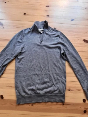 Grå halvzip tröja - Säljer nu denna haltzip så den inte kommer till användning. Det är storlek S.  Är skit dålig på att ta snygga bilder så kan lova att den är snyggare i verkligheten! 