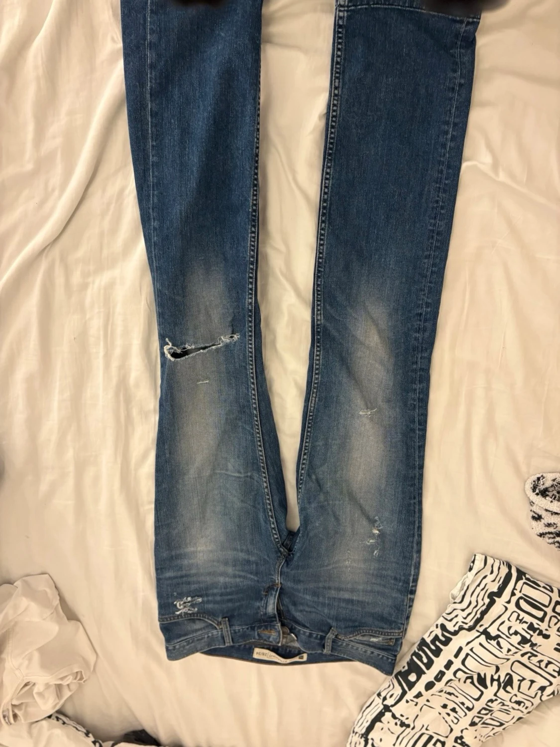 Blå raka jeans med slitningar