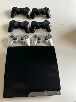 PS3 | 6 kontroller | 13 spel  - Säljer nu mitt PlayStation 3 som jag har haft under hela min uppväxt. Har 13 stycken spel som ingår och 6 fungerande kontroller varav 4 är svarta och 2 är silvriga. De är i gott skick och har alltid fungerat i min ägo. Det är kul att spela på den och det ger ordentlig nostalgi. Hör av er vid frågor 👍. 