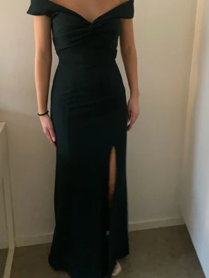 Mörkgön balklänning - Mörkgrön balklänning från bubbelroom i storlek S. Perfekt nu till studentbal mm, klänningen är uppsydd ca 2 cm, personen på bilden är 165cm lång. Har använt klänningen endast vid ett tillfälle.