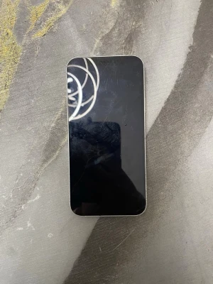 Vit iPhone 12 med dubbla kameror - Snygg vit iPhone 12 med stilren design och rundade hörn. Baksidan är i glas och har två kameror samt Apple-loggan. Framsidan har en stor skärm som täcker nästan hela ytan. Perfekt för dig som gillar modern teknik och enkel design.