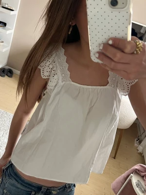 Vit blus med broderade volangärmar - Superfin vit blus med breda volangärmar i broderad spets från Zara. Super fin nu till sommaren💗