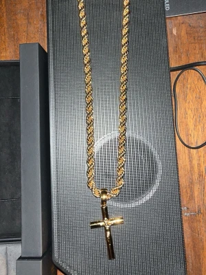 18k Guld pläterad Cordell korshalsband från Kejsar - Snyggt halsband från Kejsar. Kommer i original ask. Kedjan är 55cm lång 8mm tjock och är 18k platterad samma går för korset som är mellan storlek/M. Kedjan kan köpas separat för 1499 och kors separat för 1000. Paketpris 2499