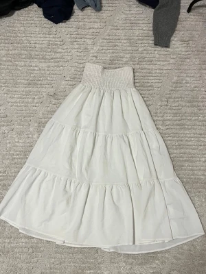 Somrig vit långkjol - Somrig vig långkjol. Ej genomskinlig. Säljer för den är lite för kort för mig. Använt den som klänning över bikini många gånger också. 