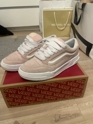 Vans rosa sneakers - Snygga rosa Vans sneakers i mocka med vit sula och vita detaljer. Klassisk låg modell med breda vita skosnören och ikonisk sidostrip i vitt. Perfekta för en trendig streetwear-look och passar till det mesta i garderoben.
