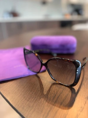 Gucci brunsvarta oversized solglasögon - Snygga oversized solglasögon från Gucci med brunmelerad båge i plast och mörka tonade glas. Kommer med lila fodral och putsduk. Perfekta för dig som vill ha en lyxig och trendig look.