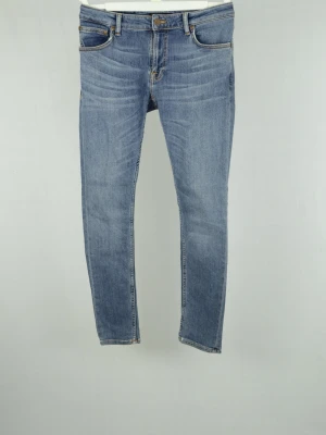 Nudie Jeans  - NUDIE JEANS Storlek : 29/30 Modell : Skinny lin Mått : A = 37CM - B = 99CM Användning : Jeansen är i ett fint skick utan defekter Nypris : Cirka 2000SEK Modellen på bilden : 182CM och väger 78KG