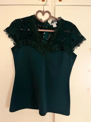 Mörkgrön spets topp  - En jätte söt mörkgrön spets topp från h&m så fin fest topp! Tyvärr har den inte kommit till användning för mig, den är bara använd 1 och är i nyskick!