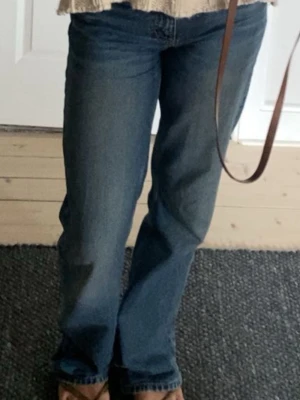 Blå raka jeans med normal midja - Säljer ett par klassiska blå jeans med rak passform och normal midja. Jeansen har fem fickor och stängs med dragkedja och knapp. Perfekta till vardagslooken och passar till det mesta. Materialet är denim i bomull. Kan posta de direkt!!