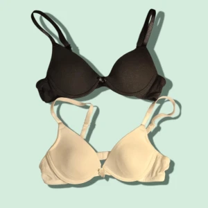 2-pack bh 65A svart & vit - Säljer två lätt använda T-shirt bhar i svart och vit med släta kupor och justerbara axelband. Båda har en enkel och stilren design utan spets eller extra detaljer, perfekta under tighta toppar. Materialet känns mjukt och bekvämt mot huden. 