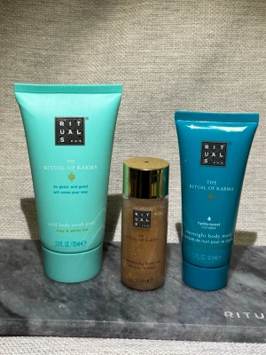 Nytt! Rituals The Ritual of Karma set - Helt nya! 3 delar. Säljer ett set från Rituals The Ritual of Karma med tre produkter: en mild body scrub paste med lera och vitt te (70 ml), en shimmering body oil i guldton (30 ml) och en overnight body mask (40 ml). Fräscha turkosa och guldiga förpackningar, perfekt för kroppsvård.