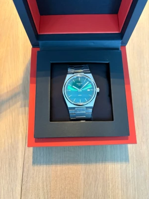 Ny Tissot PRX T137.410.11.091.00 - Helt ny Tissot PRX T137.410.11.091.00 i grön säljes 💚  En mycket populär modell från Tissot PRX-serien med stilren och modern design. Den gröna urtavlan ger ett fräscht och exklusivt uttryck som passar lika bra till vardags som till mer uppklädda tillfällen. Med sin slimmade profil och integrerade länk är detta en klocka som verkligen sticker ut – på rätt sätt.  Klockan är helt oanvänd och fortfarande inplastad. Inga hairlines eller märken förekommer. Betalning sker via extern länk genom Stripe.